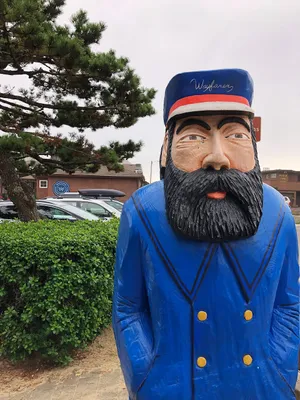 Colorful statue of a man with a thick black beard and blue coat
