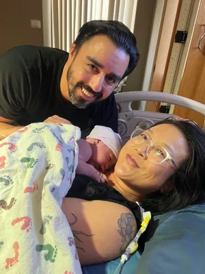 Andrew, Theresa, and a newborn baby in a hospital