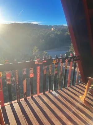 Sun-blasted overlook from a chalet balcony with skis for rails