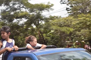 Kids riding in the back of a pickup truck at high speed