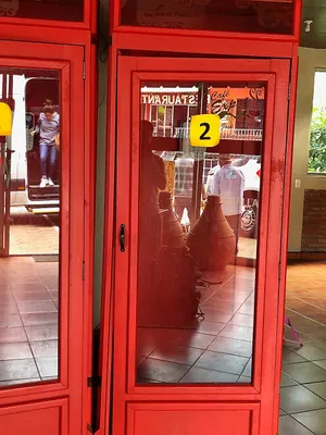Reflection of a shop in the glass of a red cabinet