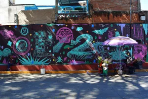 Wall mural with neon pink and turquoise Olmec art, skull, snake, bat, musical instruments